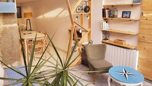 Een knus ingerichte kamer met een houten boekenkast, een eettafel en een stoel.