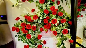 Un mur décoré de roses rouges disposées en cascade.
