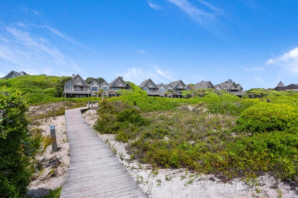 Un complejo turístico frente al mar con varias villas privadas unidas por una pasarela de madera.