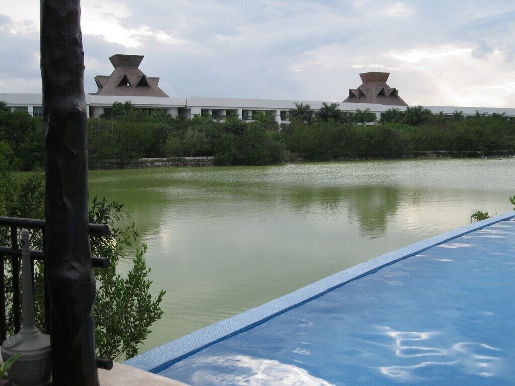 A swimming pool with a view of a building with unique architecture in the background.