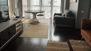 A living room with a dining table, sofa, and TV.