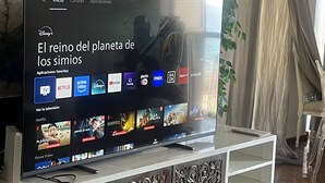 A flat-screen TV on a white cabinet with ornate carvings, displaying a streaming service interface with various apps.