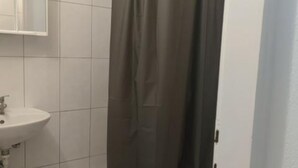 Un baño con un lavabo blanco, un espejo encima y una cortina de ducha.