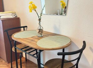 Enjoy meals in this intimate dining area with a round table, two chairs, and a mirror above.