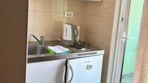 A compact kitchenette with a sink, a kettle, and a small refrigerator. - Apartments Villa Mira Roso - Studio Apartment 3 (Makarska)