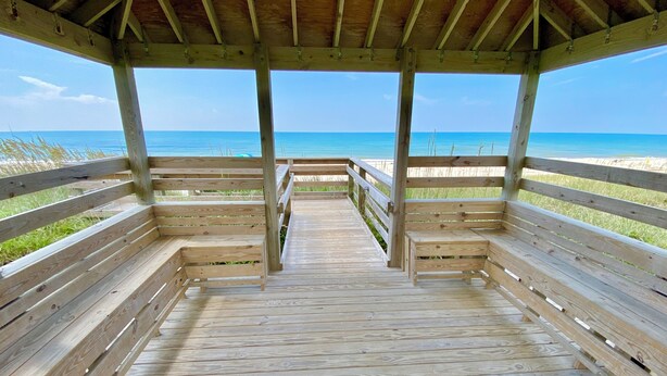 A wooden pier leading to a beach with a clear view of the ocean. - Cozy studio with AC, WiFi, pool and is just steps from the beach! (Atlantic Beach)