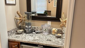 A kitchen with a granite countertop, a blender, a coffee maker, and a built-in oven. - Charming 2-bedroom condo in delightful Pawleys Island with AC, WiFi.   (Pawleys Island)