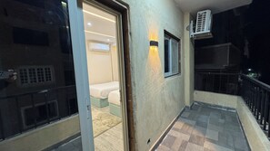 An interior corridor with a sliding door leading to a room with a bed and an air conditioning unit mounted on the wall. - Pyramids Hotel (Giza)