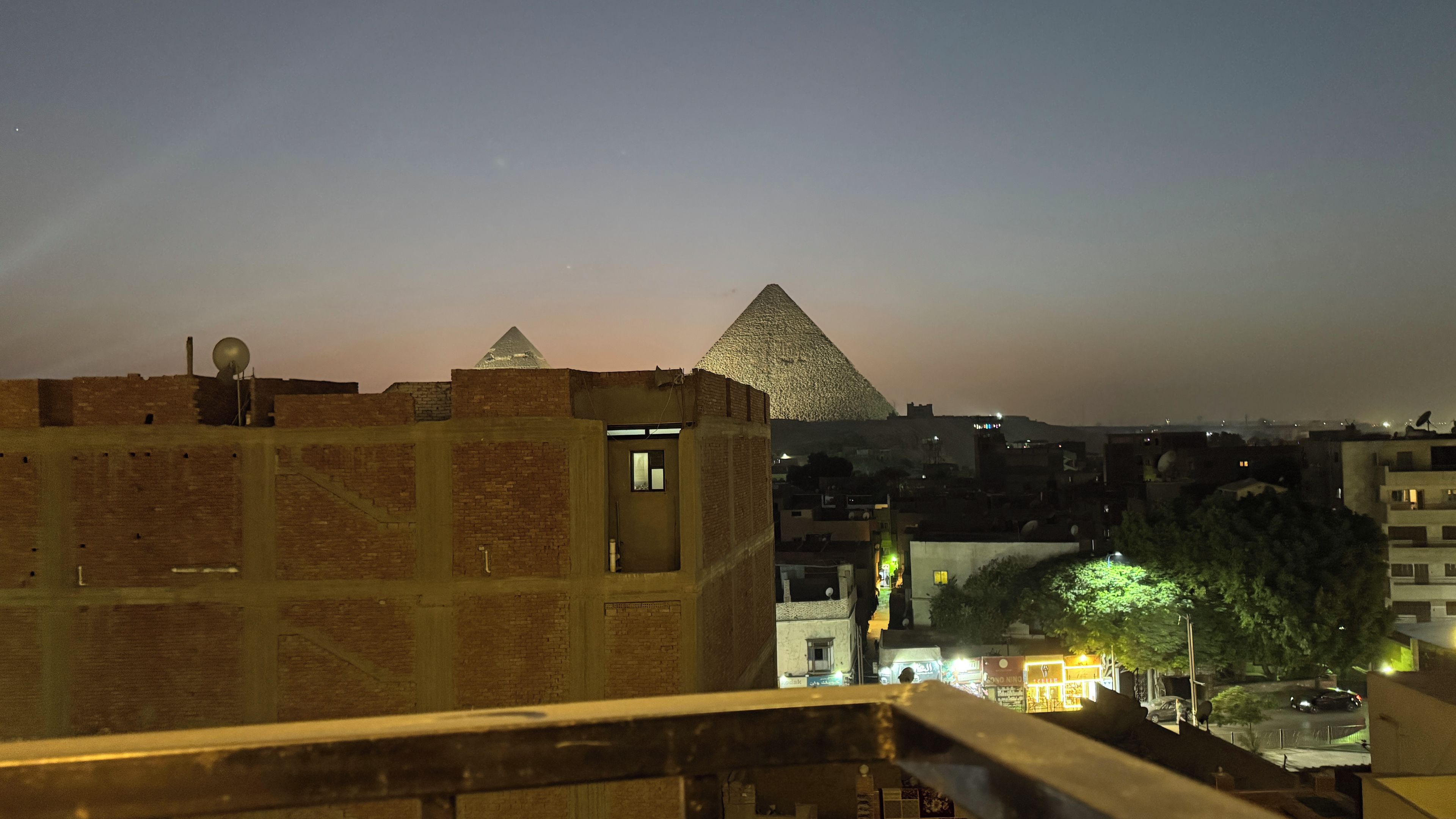 A view of a pyramid and a building with a satellite dish.