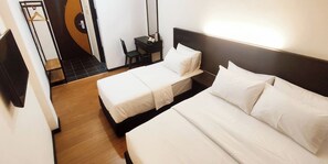 Habitación de hotel con dos camas, un escritorio y una silla.