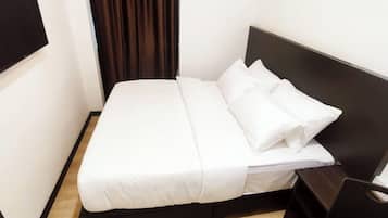 Ein ordentlich bezogenes Bett mit weißer Bettwäsche in einem Hotelzimmer.