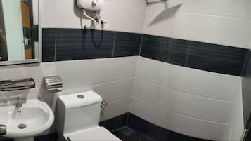 Ein kleines Badezimmer mit einem weißen Waschbecken, einer Toilette und einem Spiegel.