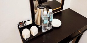 A hotel room's minibar with a coffee maker, water bottles, and a tray with cups and a menu. - ABA Hotel Sarawak By Zuzu (Kota Samarahan)