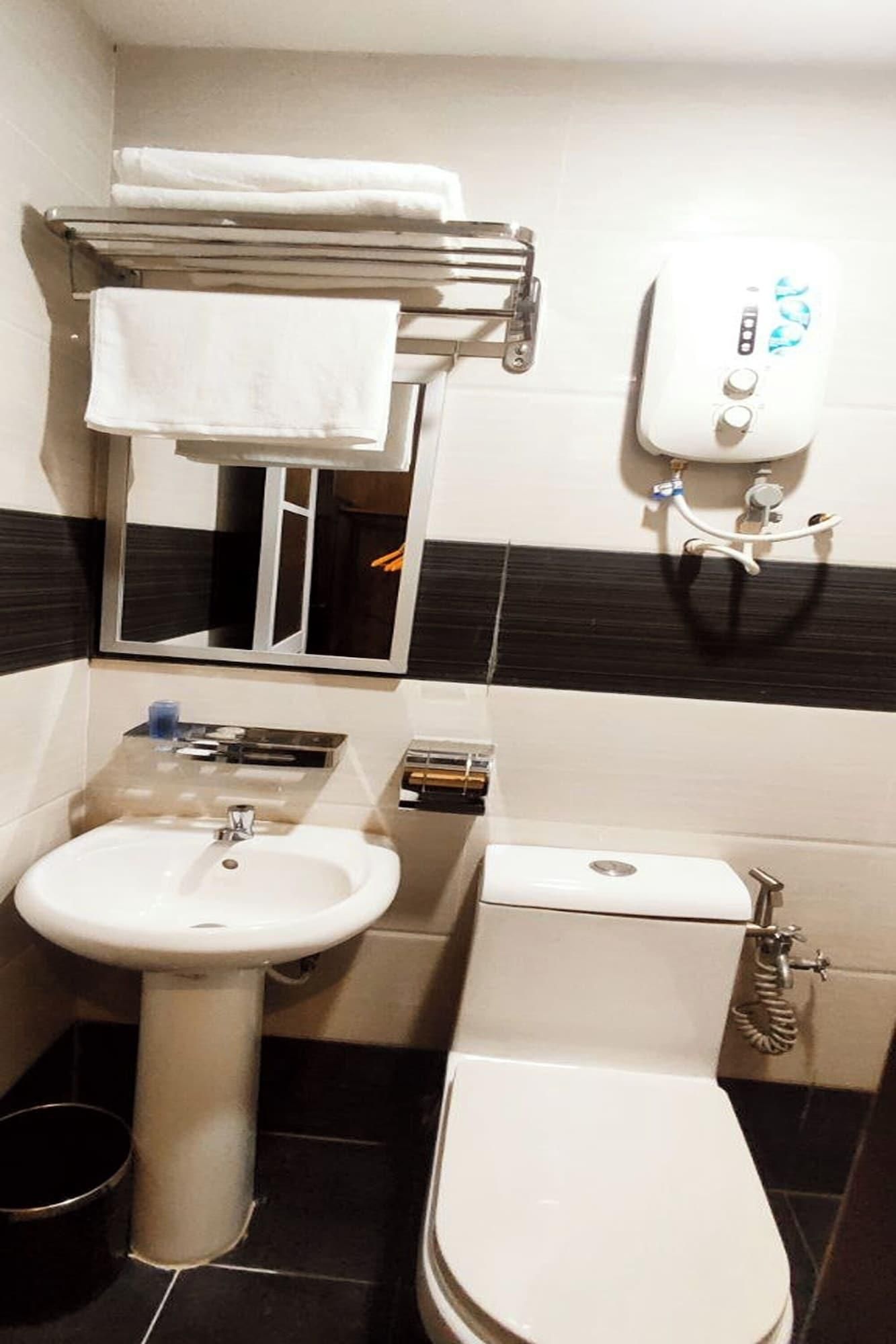 A bathroom with a sink, toilet, and towel rack.