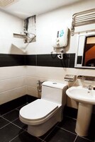 Un baño pequeño con inodoro, lavabo y secador de manos.