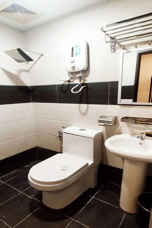 A compact bathroom with a toilet, sink, and a towel rack. - ABA Hotel Sarawak By Zuzu (Kota Samarahan)