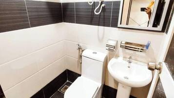 A bathroom with a toilet, sink, and shower.