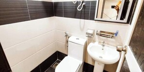 A bathroom with a toilet, sink, and shower.