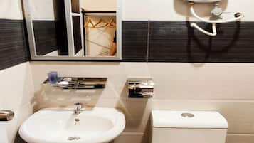 Ein Badezimmer mit Waschbecken, Toilette, Spiegel und Seifenspender.