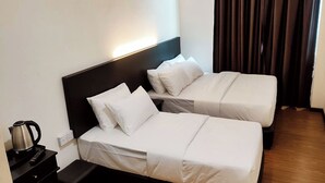 A hotel room with two single beds, a nightstand with a kettle, and a TV mounted on the wall. - ABA Hotel Sarawak By Zuzu (Kota Samarahan)