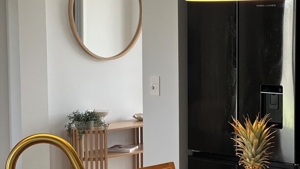 Cocina moderna con una isla central, pileta de acero inoxidable y un refrigerador negro.