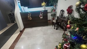 A modern living room with a Christmas tree, a dining area, and a reception desk with blue LED lights. - Skyline Suites (La Paz)