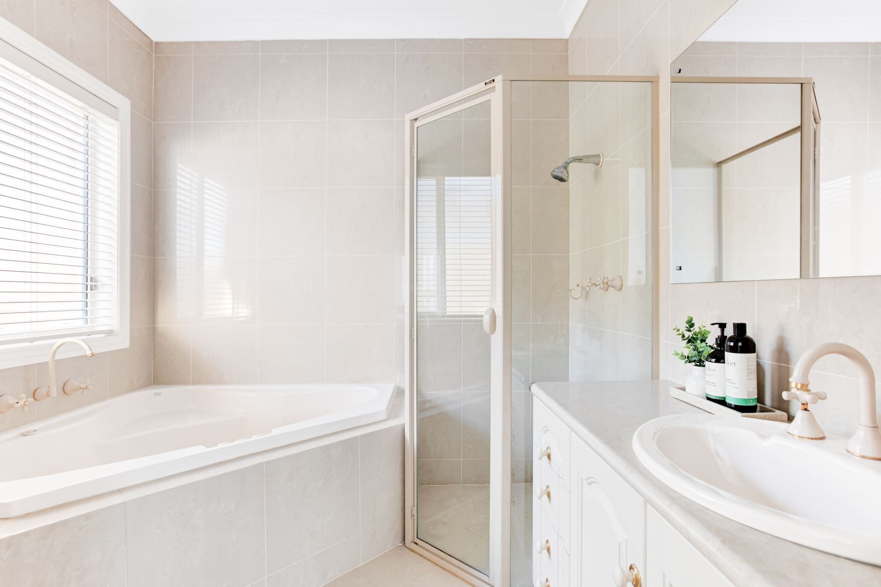 A modern bathroom with a bathtub, shower, and vanity.