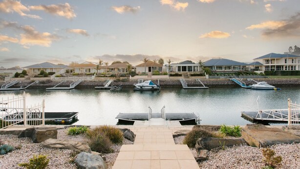 A marina with boats docked, a pathway leading to the water, and houses in the background. - The Stately Way, Wallaroo (Wallaroo)