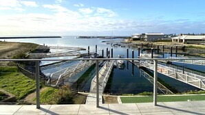 Un puerto deportivo con barcos amarrados, un puente y un edificio al fondo.