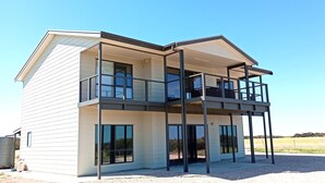A modern two-story house with a balcony on the upper floor. - Sturt Bay Retreat, Port Moorowie (Warooka)