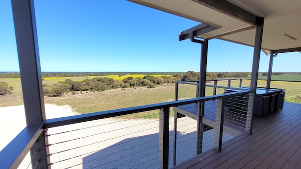 A balcony with a metal railing overlooking a rural landscape with fields and trees. - Sturt Bay Retreat, Port Moorowie (Warooka)