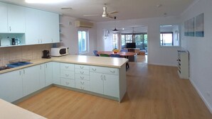 Una cucina moderna con mobili azzurri, un piano di lavoro in legno e un'area pranzo con tavolo e sedie.