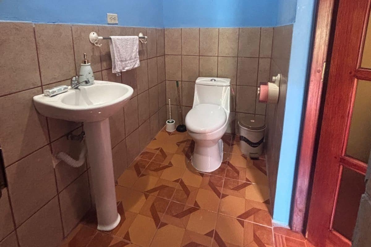 Un baño pequeño con lavamanos, inodoro y pared azul.