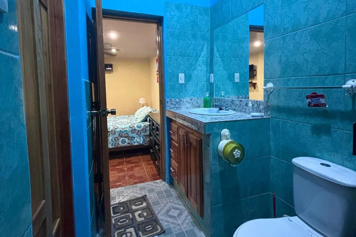 Un baño pequeño con inodoro, lavabo y zona de ducha.
