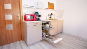 Una cocina compacta con microondas, lavavajillas y una pequeña encimera.
