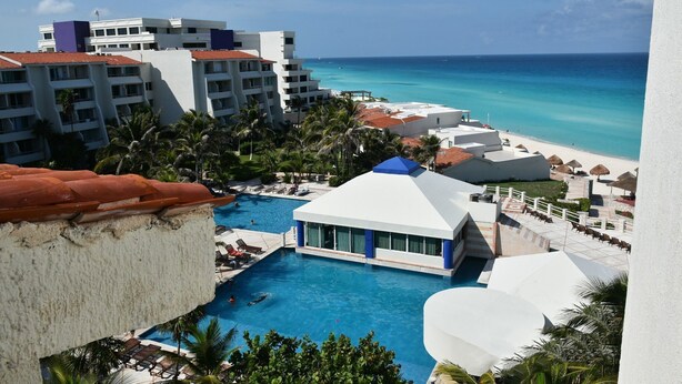 A resort with a swimming pool, beach, and ocean view. - Seaside Condo by Solymar (Cancun)