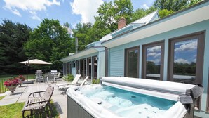 Un patio trasero con jacuzzi, mobiliario exterior y zona de patio.