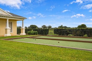 A croquet court with a building in the background. - INCREDIBLe Two-Story Home Near Disney (Kissimmee)