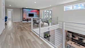 A modern apartment with a spacious living area, a kitchen with a built-in oven, and a balcony with a railing.