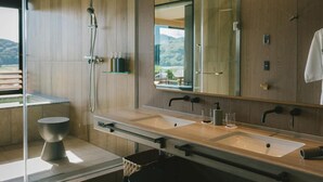 A modern bathroom with a large mirror, two sinks, a shower, and a toilet. - Hotel & Lakehouse Soka (Kyotango)