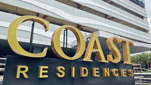 Un letrero para 'COAST RESIDENCES' con letras grandes y llamativas.