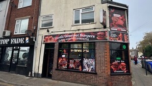 A two-story building with a sign for 'Exotic Gourmet Burgers' on the ground floor. - Cozy Affordable Place in Great Yarmouth (Great Yarmouth)