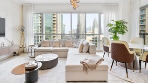 A modern living room with a sofa, coffee table, and a dining area with chairs.