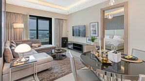 Ein modernes Hotelzimmer mit Sofa, Esstisch und Bett.