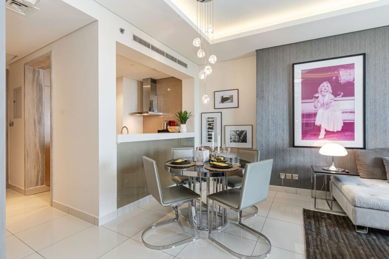 Een moderne woonkamer met een eethoek, een bank en een ingelijst schilderij aan de muur.