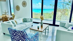 A modern living room with a large window offering a view of the ocean.