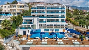 Un hôtel doté de nombreux balcons, d’une piscine et offrant une vue sur un paysage montagneux.