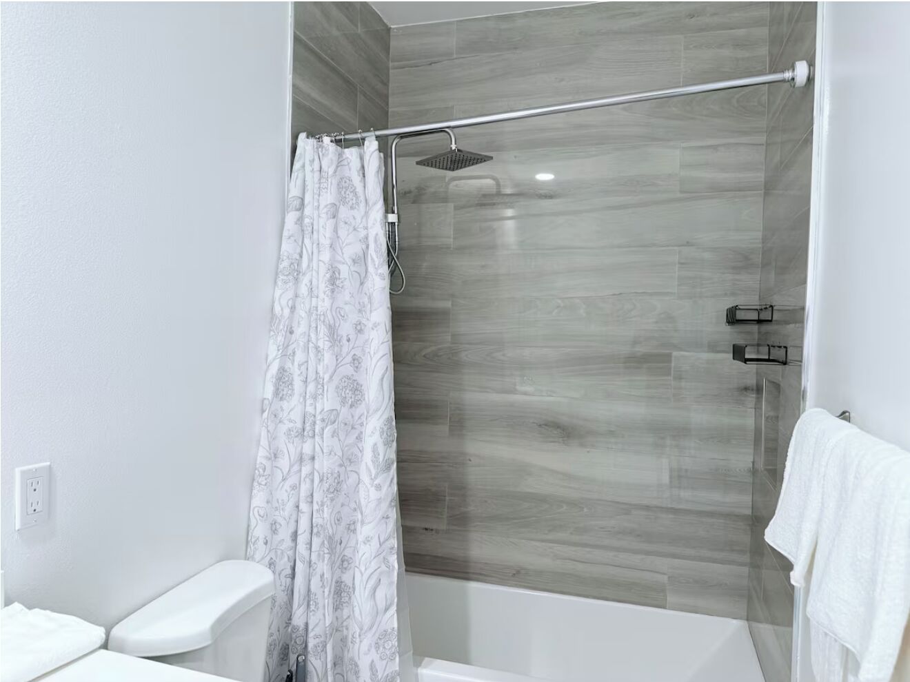 Une salle de bain moderne avec une douche à parois de verre, des toilettes blanches et un lavabo blanc.