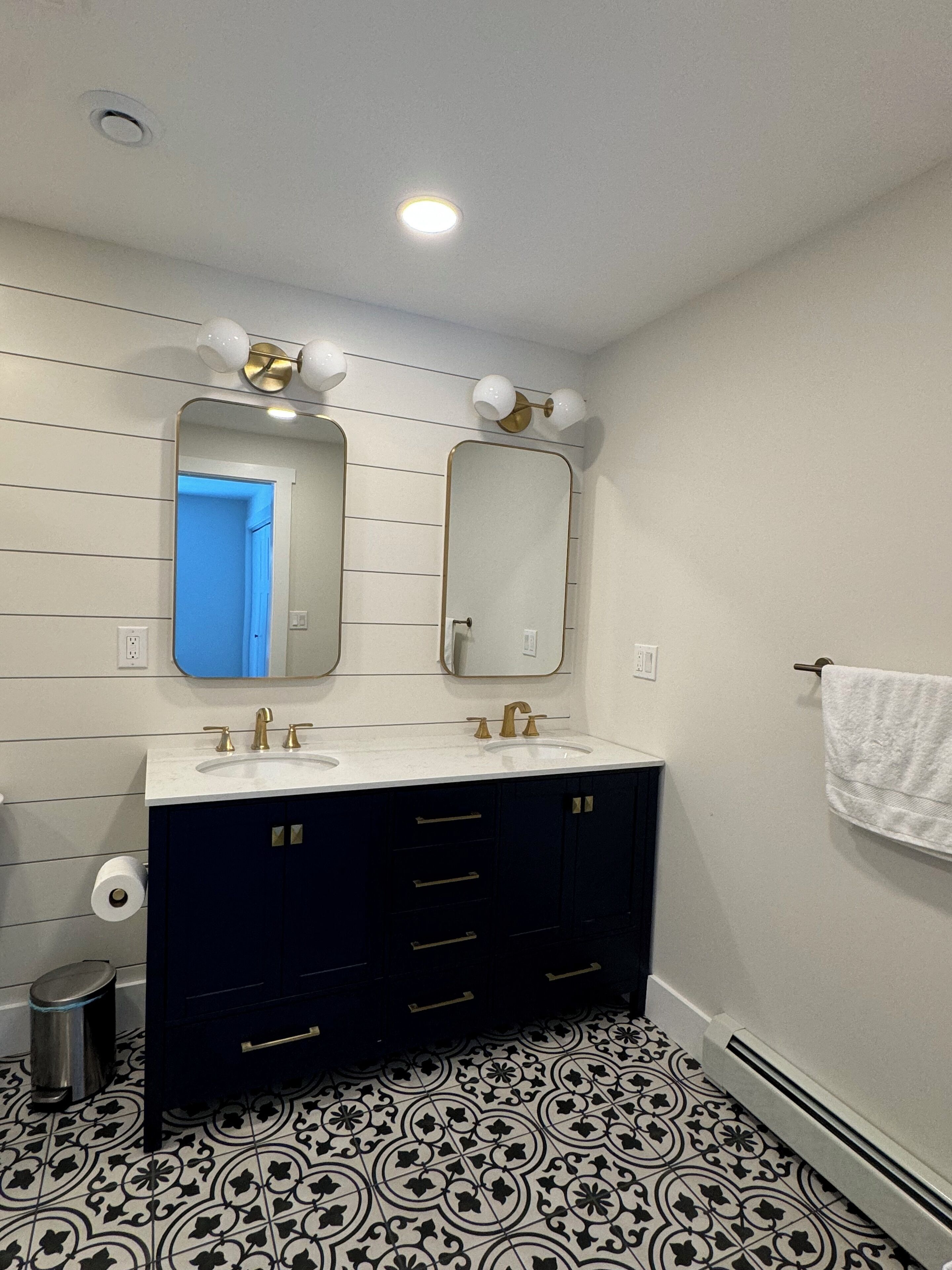 A bathroom with two sinks, a mirror, and a towel rack.