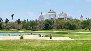 A golf course with sand bunkers and a water hazard.